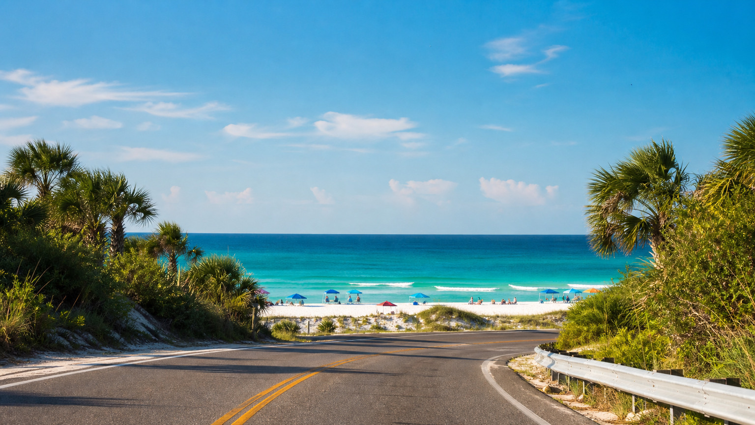 First glimpse of Destin's emerald green Gulf water from US-98, white sand beach in the distance under a clear summer sky