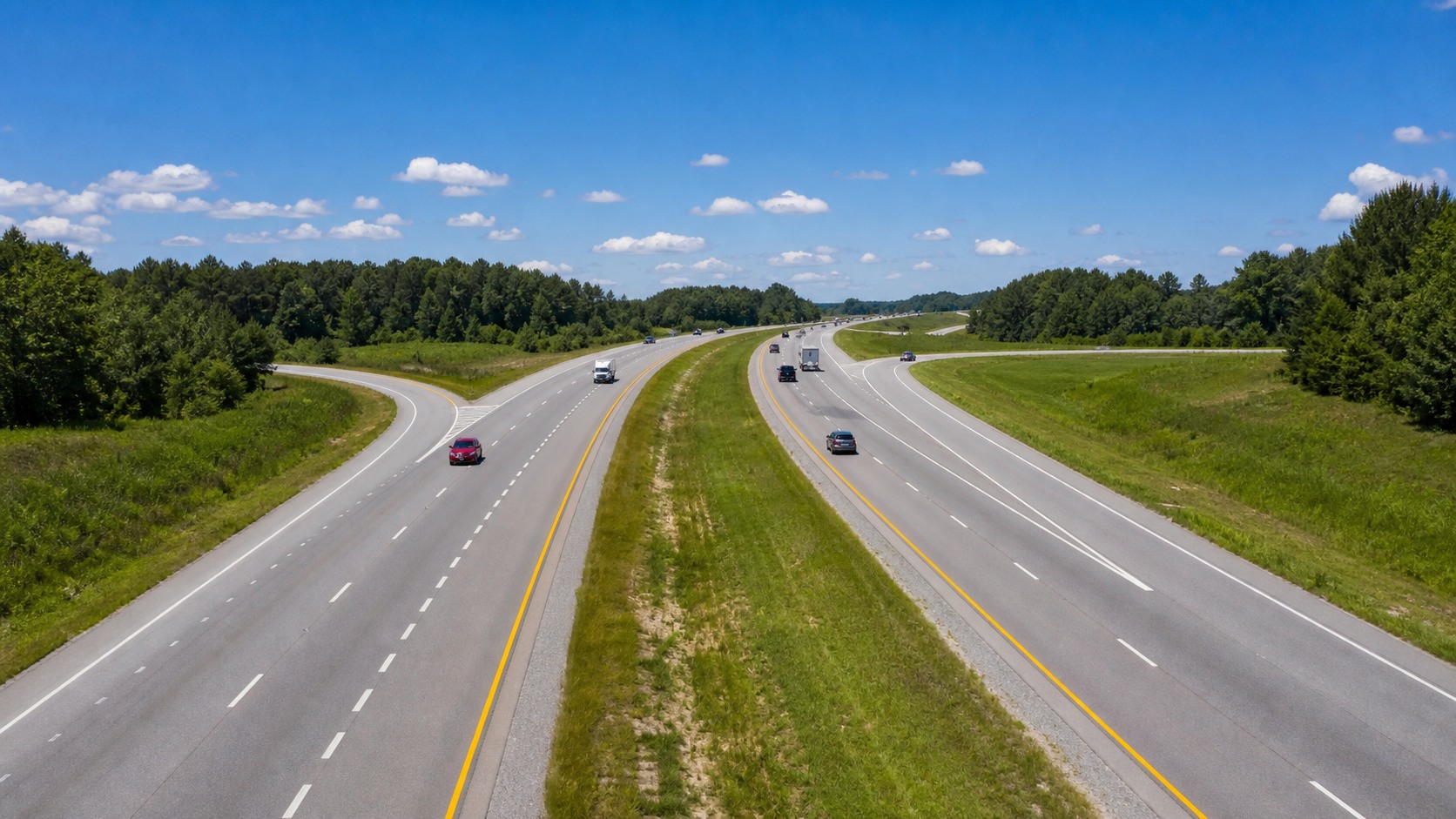 Split highway interchange in Alabama with clear blue sky overhead, summer driving conditions