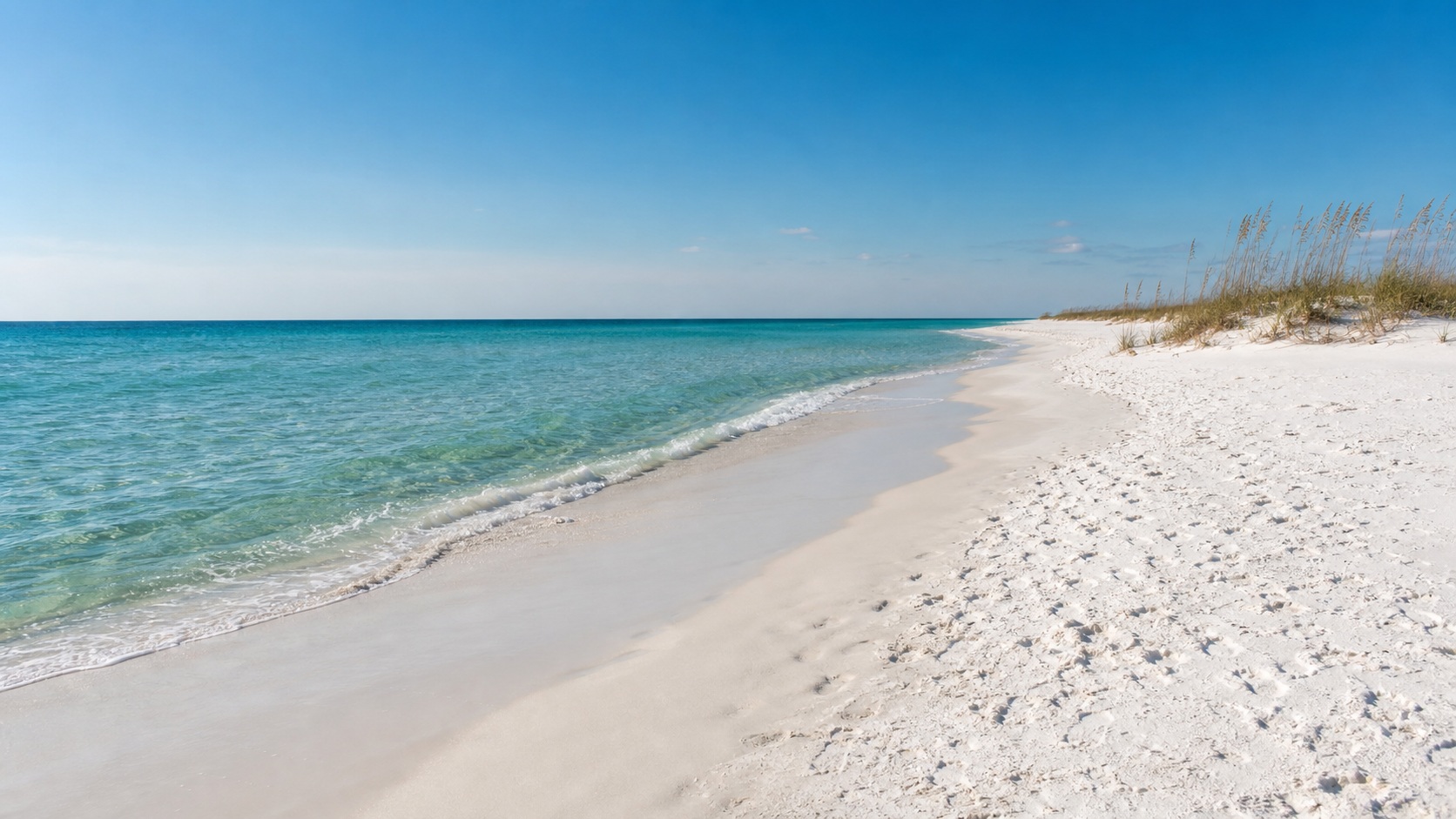 Sunny February day on Destin beach with clear emerald Gulf water and nearly empty white sand shoreline